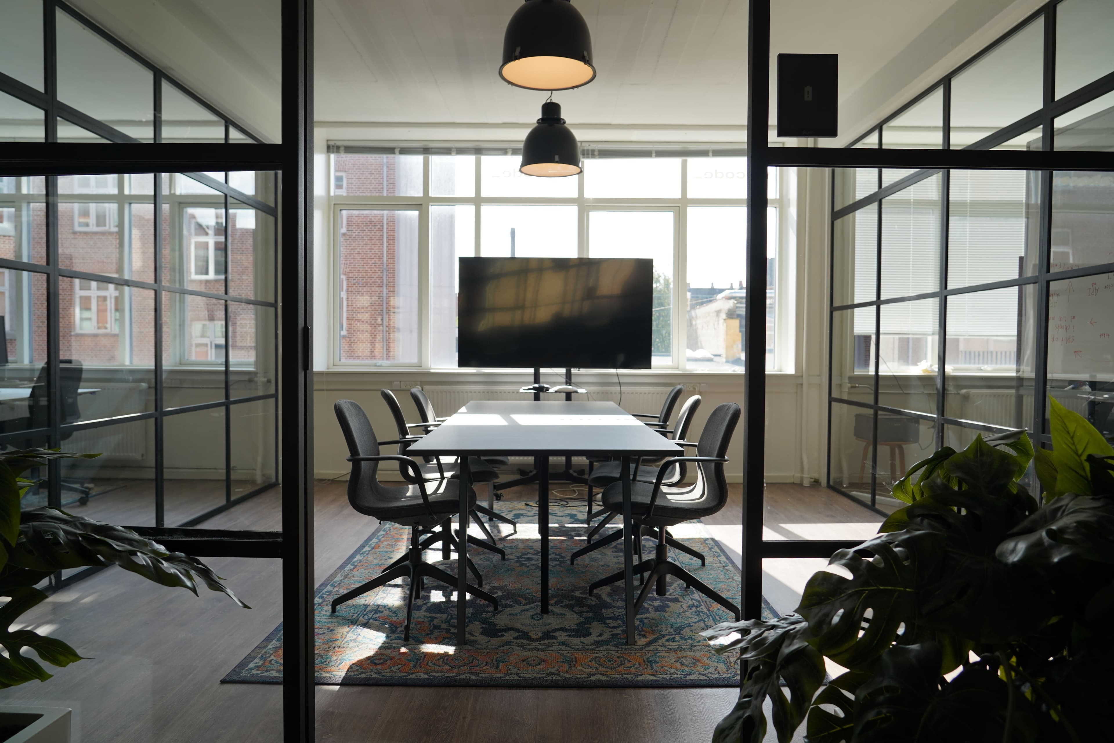 Mødelokale set gennem planter og Crittall-glas