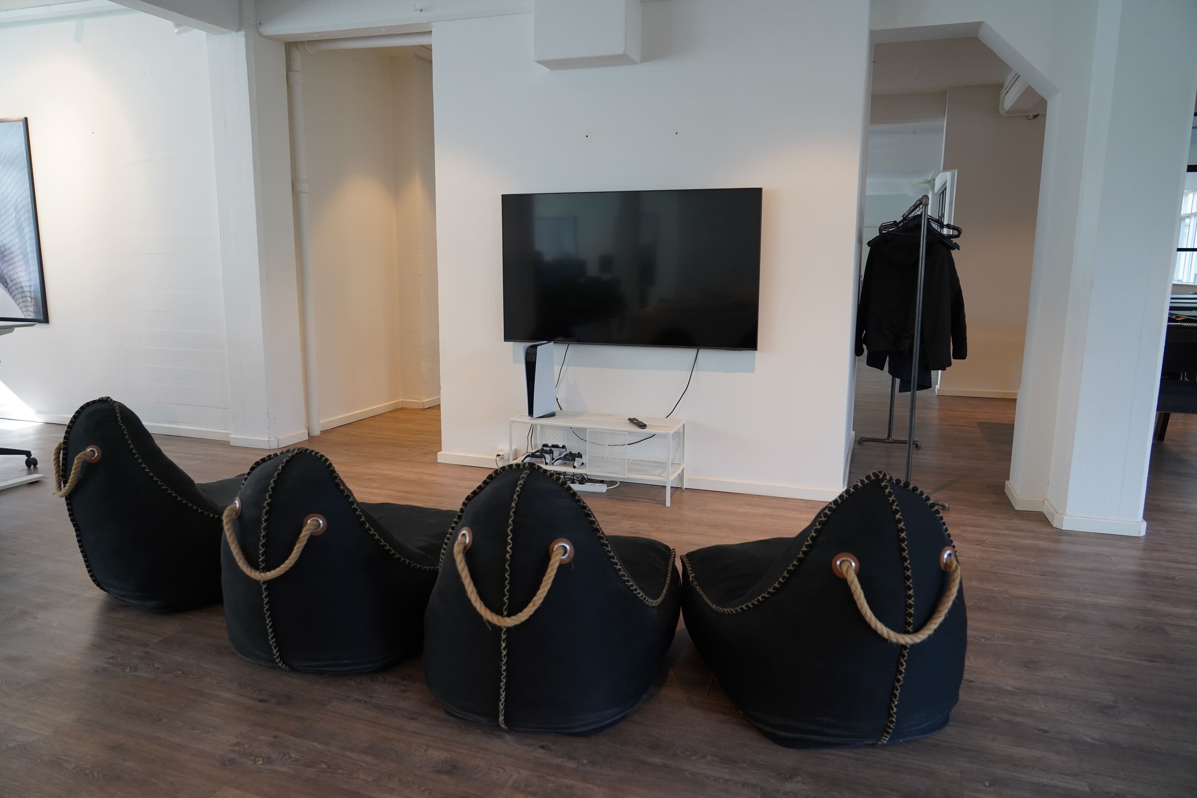 Afslapningsområde med lounge-stole, TV og PlayStation 5